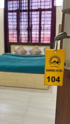 a room with a bed with a sign on a door at Hotel Sunrise Imphal in Imphal