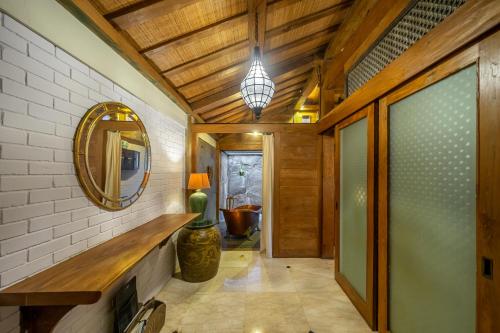 un corridoio di una casa con specchio e lampada di Villa Arumanis a Canggu