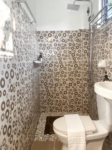 a bathroom with a toilet and a sink at Namal Apartelle - Free Scooter & GYM access in El Nido
