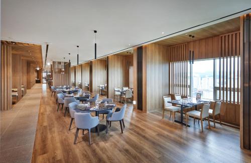 een restaurant met tafels en stoelen en een groot raam bij Hotel Interciti in Daejeon