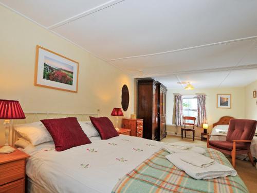a bedroom with a large white bed with red pillows at Manor Villa in Llanrian