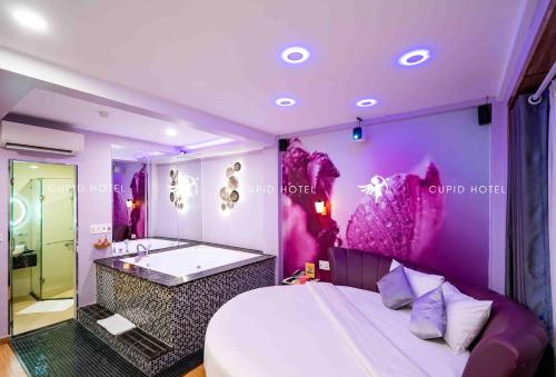 - une chambre avec une baignoire, un lit et un miroir dans l'établissement Cupid Hotel 2, à Hô-Chi-Minh-Ville