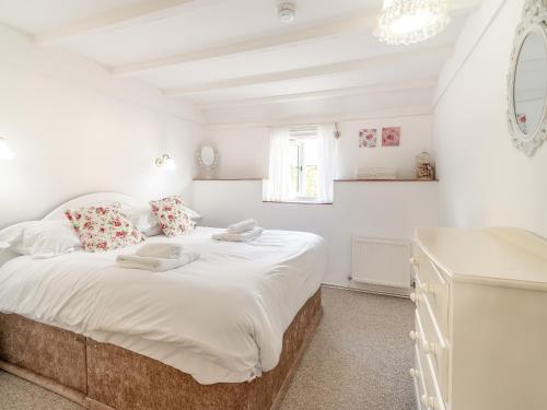 a white bedroom with a large white bed and a window at Granary Cottage-uk45587 in Verwick