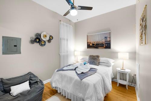 a white bedroom with a bed and a ceiling fan at Boutique 1br With Charm And Style in Philadelphia