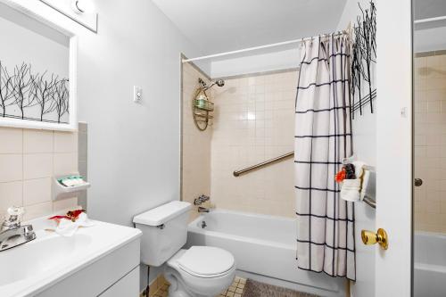 a bathroom with a white toilet and a tub and a sink at Boutique 1br With Charm And Style in Philadelphia