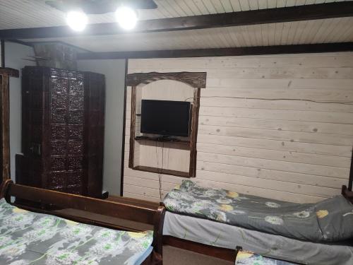 a room with two beds and a flat screen tv at Садиба Тарниця in Krivorovnya