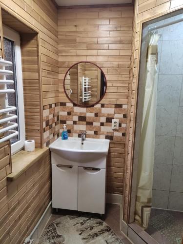 ein Bad mit einem Waschbecken und einem Spiegel in der Unterkunft Садиба Тарниця in Krivorovnya
