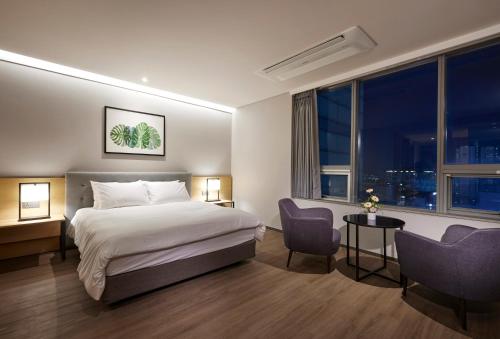 a hotel room with a bed and a large window at Hotel Interciti in Daejeon