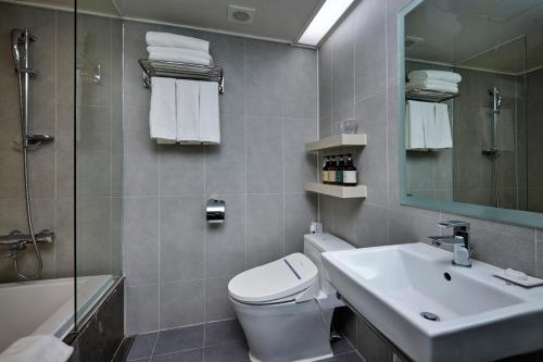 a bathroom with a toilet and a sink and a shower at Hotel Interciti in Daejeon