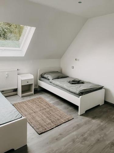 a white bedroom with a bed and a window at Wohnen im 3 Ländereck! Essen, Mülheim, Oberhausen. BSDG in Essen
