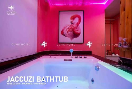 uma banheira com um flamingo num quarto cor-de-rosa em Cupid Hotel 2 em Ho Chi Minh