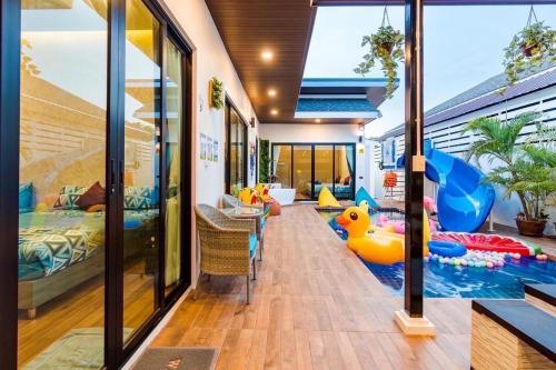una casa con piscina y un pato inflable en el pasillo en White Cloud Luxury Pool Villa Cha Am en Cha Am