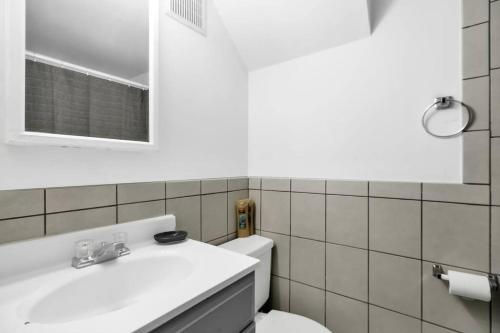 La salle de bains est pourvue d'un lavabo blanc et de toilettes. dans l'établissement Uniquely Designed Metropolitan Apt In Center City, à Philadelphie