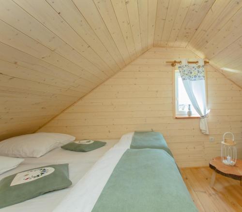 a bed in a wooden room with a window at Kaszubskie Spa Ziółko in Strzepcz