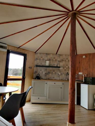 a kitchen with a large ceiling with a table and chairs at Kaszubskie Spa Ziółko in Strzepcz