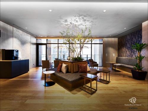 a living room with a couch and a table at DEL style Osaka-Shinsaibashi by Daiwa Roynet Hotel in Osaka