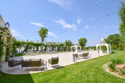 a patio with chairs and tables in a park at Hotel Parco delle Querce in Crispiano