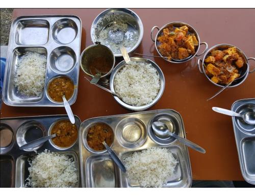 a table with many trays of food on it at Mussoorie Camp Resort in Mussoorie