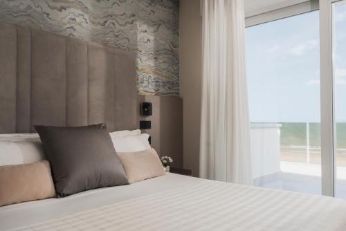 a bedroom with a bed with a large window at Hotel Ascot Riccione in Riccione