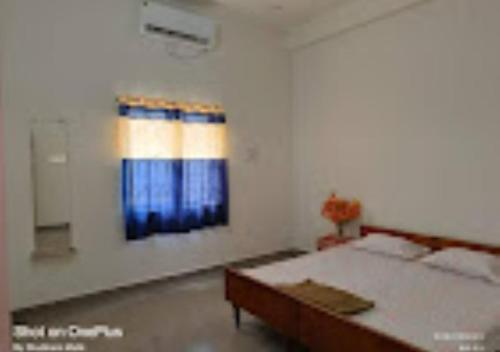 een witte kamer met een bed en een raam bij Hotel Ashirwad Palace Bihar 