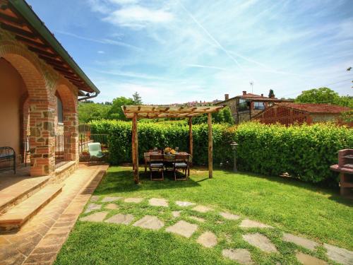 a wooden pergola with a table in a yard at Luxurious apartment in Lucignano with views in Lucignano
