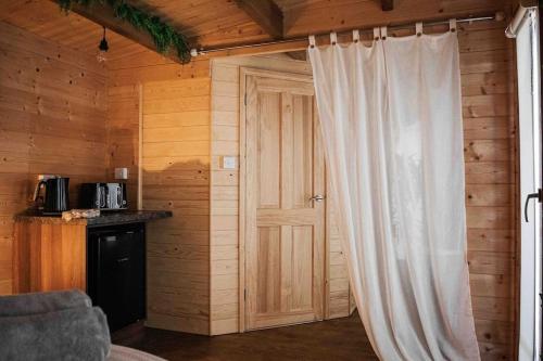a room with a door and a curtain in a room at Summerhouse @ 73 (Forest of Dean) Gloucestershire in Coleford