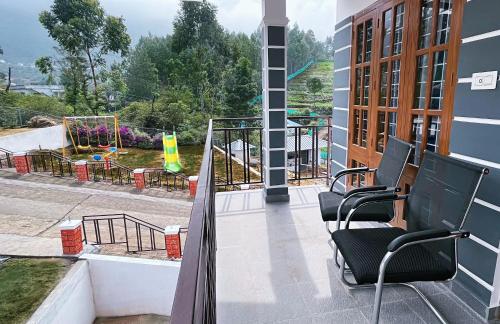 a balcony with chairs and a view of a playground at Moon Wings Mountain Resort, Kanthalloor in Kanthalloor