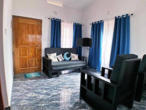 a living room with blue curtains and a couch at Moon Wings Mountain Resort, Kanthalloor in Kanthalloor