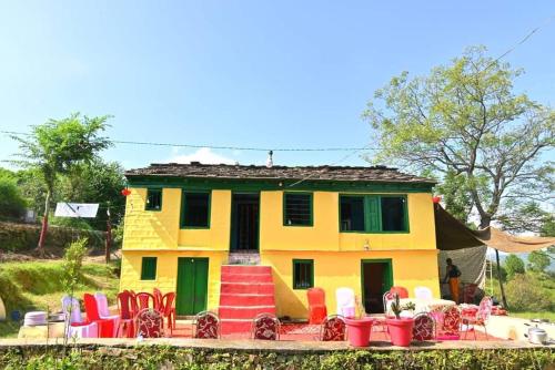 een huis met kleurrijke stoelen ervoor bij Himalayan and Nature View Homestay in Almora