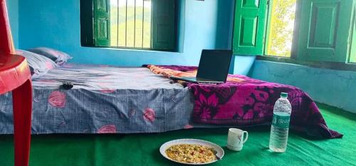 um computador portátil sentado numa cama com um prato de comida em Himalayan and Nature View Homestay em Almora