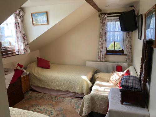a attic room with two beds and a couch at Hoots End in Wool