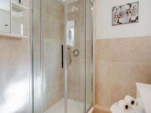 a shower with a glass door in a bathroom at Dairy Cottage-uk45593 in Verwick