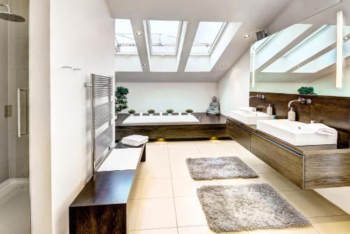 a bathroom with two sinks and a bath tub at Sky View Salzburg in Salzburg