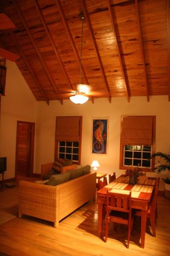 a living room with a couch and a table at Weezie's Ocean Front Hotel and Garden Cottages in Caye Caulker