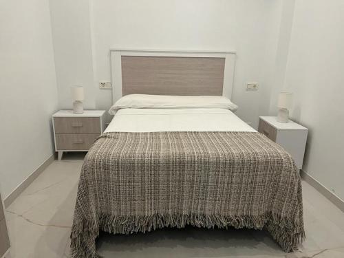 1 dormitorio con 1 cama grande y 2 mesitas de noche en Casa Puerta de Almodovar, en Córdoba