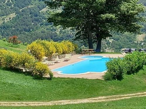 una piscina con sillas y una mesa en un patio en Stunning Villa in Apecchio with Jacuzzi, en Apecchio