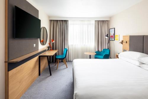 a hotel room with a bed and a flat screen tv at Holiday Inn London - Gatwick Airport, an IHG Hotel in Horley