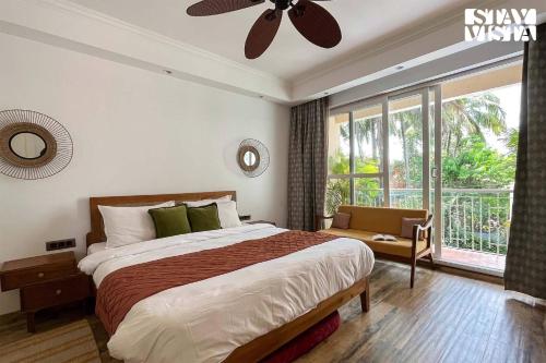 a bedroom with a large bed and a large window at StayVista at Villa Amethyst with Pvt Pool & Jacuzzi in Saligao
