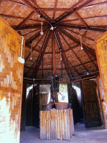 a room with a large wooden ceiling with a large pot at Tropical Hostel in Ko Phayam