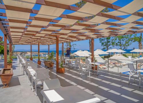a patio with white chairs and tables and umbrellas at Le Bleu Hotel & Resort Kusadasi in Kusadası