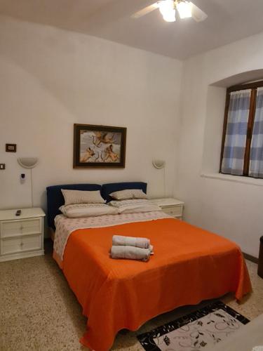 1 dormitorio con 1 cama con manta naranja en Appartamento Speranza, en Pisogne