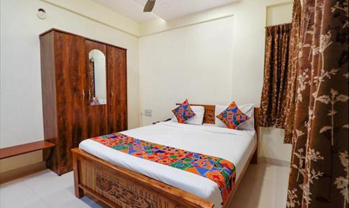 um quarto com uma cama e um armário de madeira em FabHotel Kings Inn And Suites em Bangalore