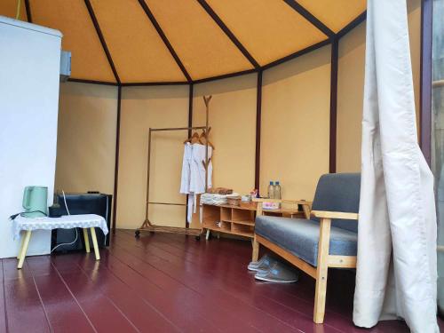 a room with a tent with a chair and a table at บ้านไร่นายสิงห์-Banrainaysing in Ban Huai Khai