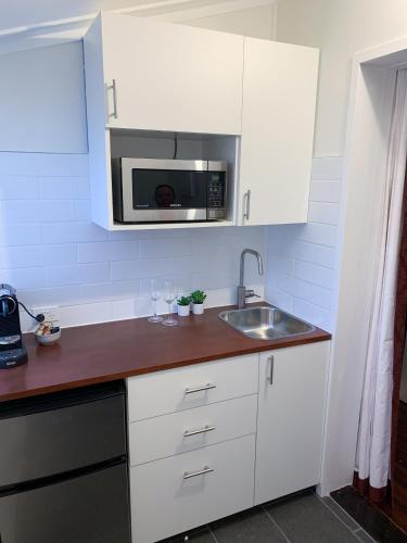 a kitchen with a sink and a microwave at West End Studio 3 in Brisbane