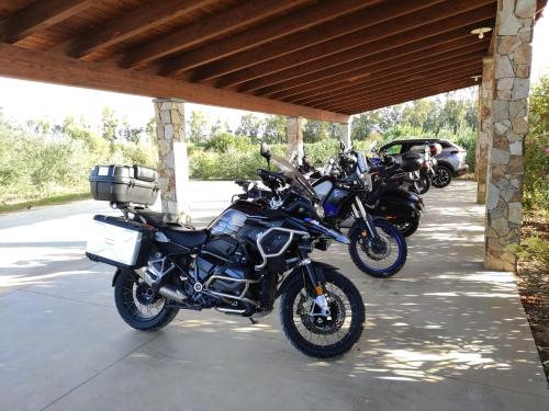 eine Reihe von Motorrädern, die unter einem Gebäude geparkt sind in der Unterkunft Agriturismo Is Solinas in Masainas