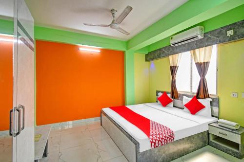 een slaapkamer met een oranje en groene muur bij Collection O Hotel 7dayz Inn Near City Centre 2 in Calcutta