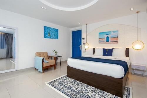 una camera con letto, sedia e tavolo di Lucia Beach Hotel a Da Nang