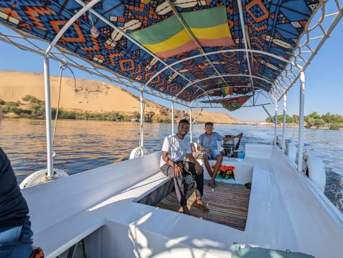 two men sitting on a boat on the water at Nile View Guest House in Aswan