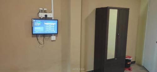 une télévision sur un mur à côté d'une armoire à médicaments dans l'établissement Hotel Lii View Labis, à Labis