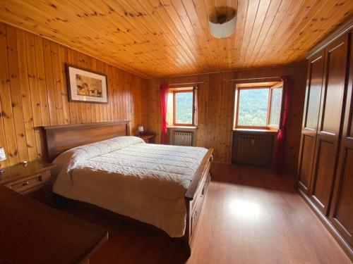 a bedroom with a bed in a wooden room at Lignod - Appartamento con 2 Camere da Letto in Champoluc